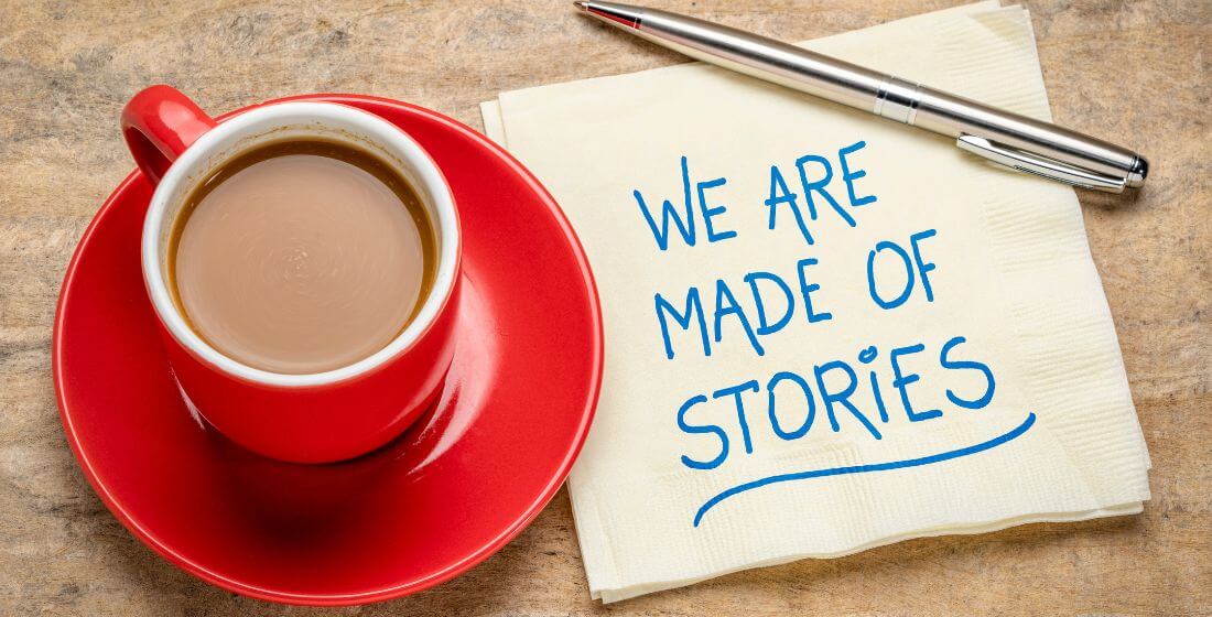 'We are all made of stories' written on a napkin next to a cup of tea.