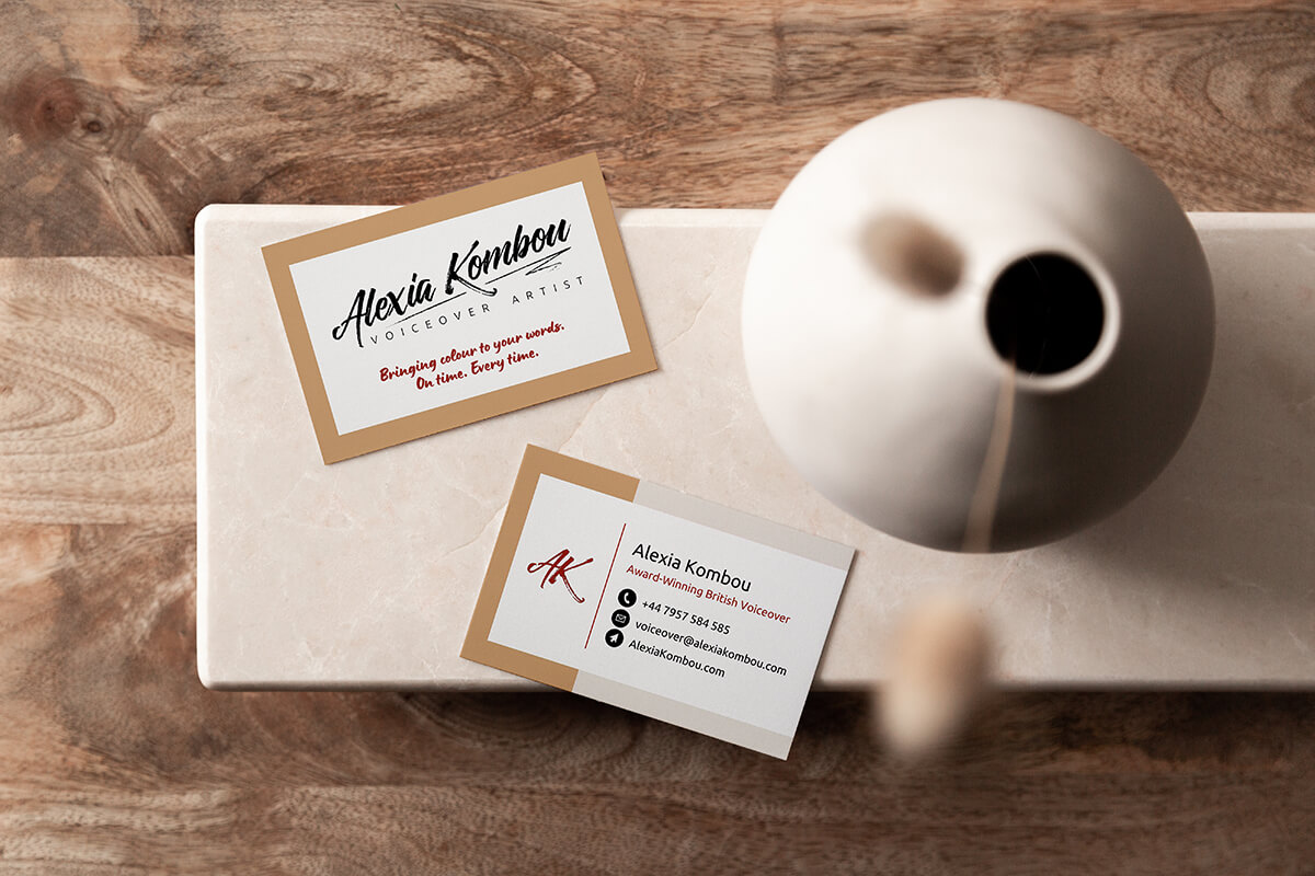 Business card design for Alexia Kombou shown from above on a small marble table with wooden floor.