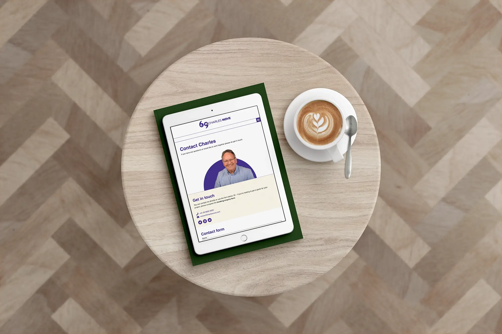 Presenter and Voice Artist Charles Nove's website contact page on an ipad which is on a pale wooden table.