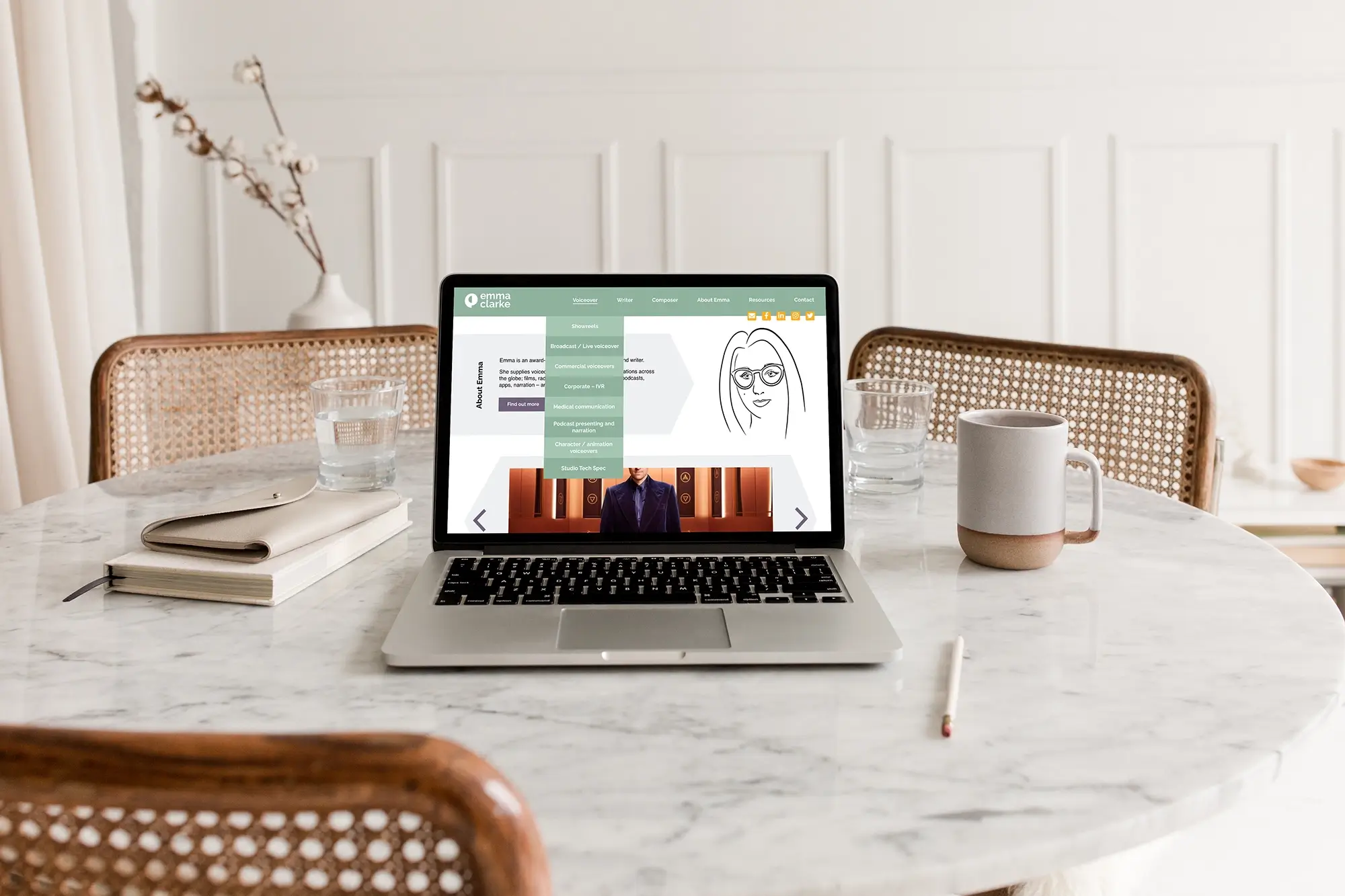 Emma Clarke voice actor website menu on a laptop on a marble table.